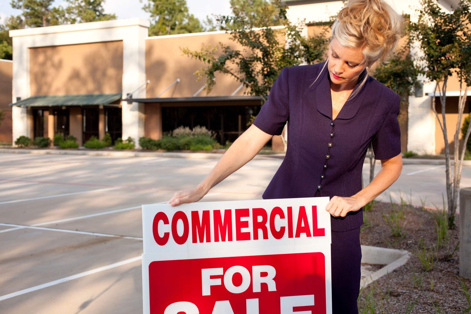 Real Estate agent with commercial sign on stripmall property